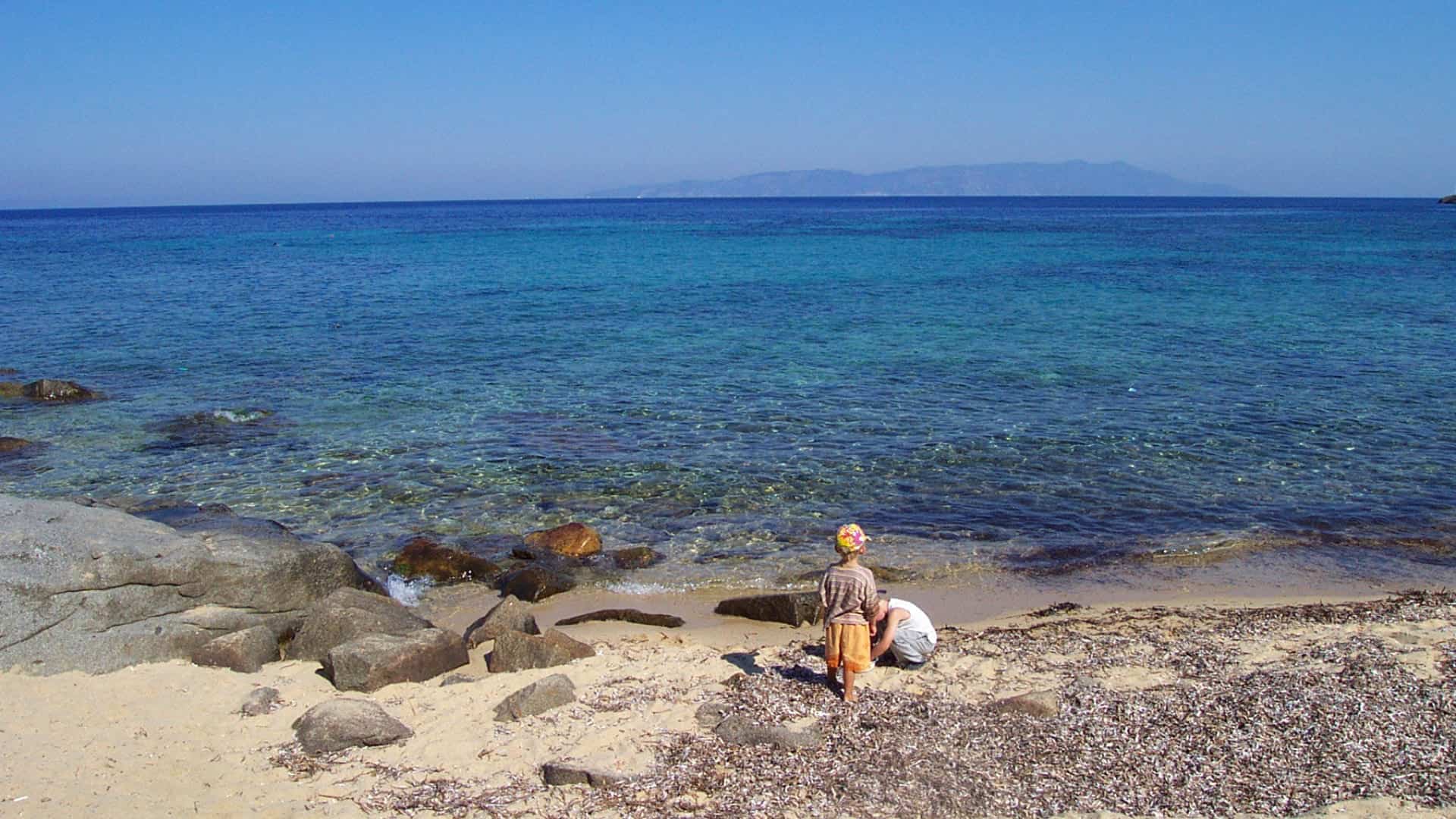 Two children on the shoreline of Cala dell’Arenella on Giglio Island. Photo by Patpatpat